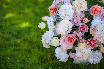 Vintage vase with roses and Hydrangea, eucalyptus bouquet outdoor on the grass