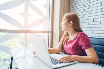 Asian girl working at a coffee shop with a laptop.female freelancer connecting to internet