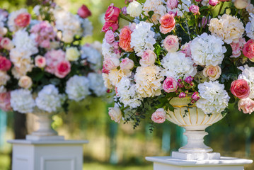 Vintage vase with roses and Hydrangea, eucalyptus bouquet outdoor on the grass