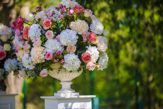 Vintage vase with roses and Hydrangea, eucalyptus bouquet outdoor on the grass