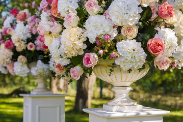 Vintage vase with roses and Hydrangea, eucalyptus bouquet outdoor on the grass