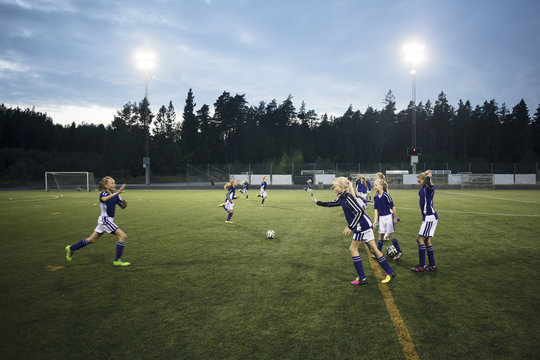 Girls running during soccer drills on field