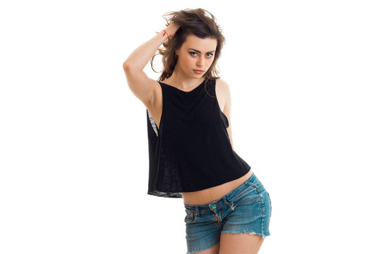 brunette teen in denim shorts and a black t-shirt sexy poses on camera