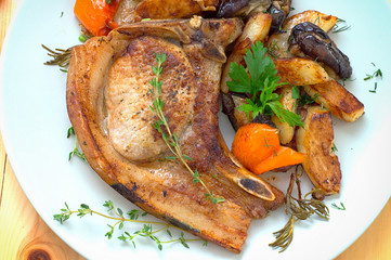Grilled pork steak and vegetables on the grill. Horizontal, rustic style. Wooden background. Close-up. Top view
