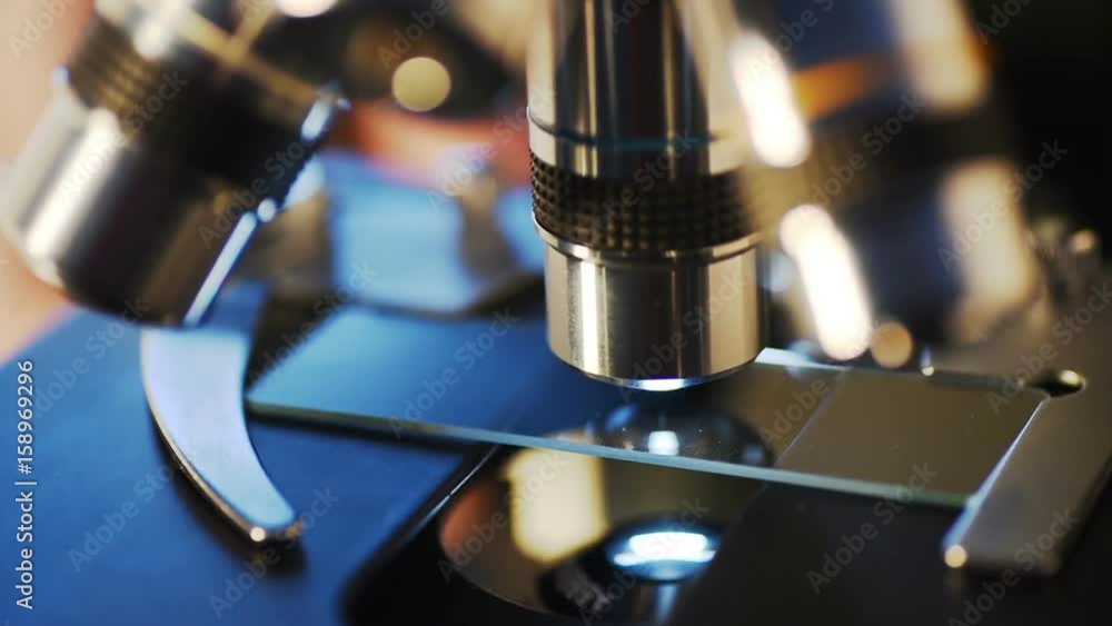 Poster researchers working in lab with microscope, close up