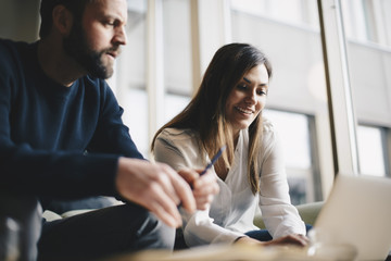 Low angle view of business colleagues using laptop at office lobby