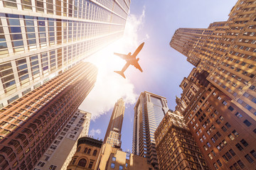 Obraz na płótnie Canvas plane over highrise buildings