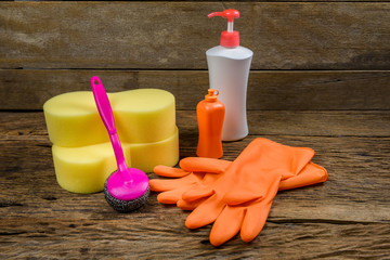 cleaning supplies and gloves on wooden background