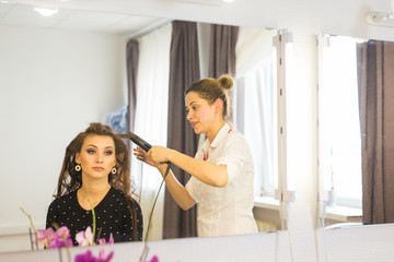 Hairdresser doing haircut for women in hairdressing salon. Concept of fashion and beauty. Positive emotion.