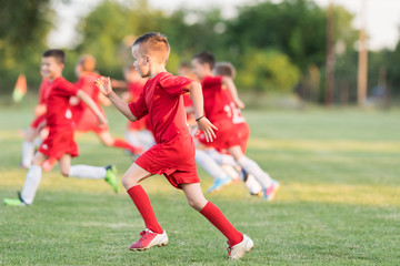 Kids soccer football - children players exercising before match on soccer field