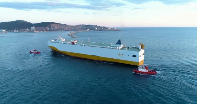 Tugboats accompany the dry cargo ship to the port.