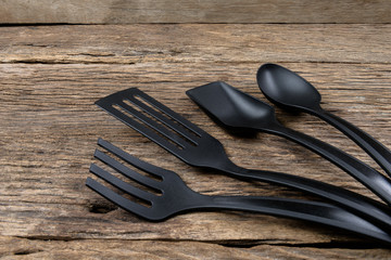 black plastic kitchen set skimmer, spade of frying pan on wooden