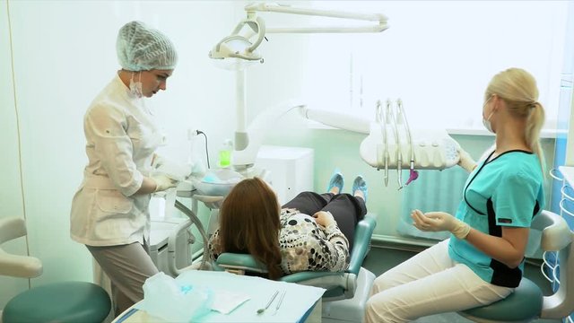 The woman the dentist has stopped treating and removes a disposable scarf from the patient