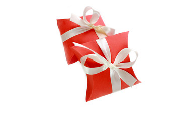 Two small red gift boxes with white ribbon