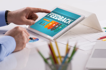 Businessman working on tablet with FEEDBACK on a screen