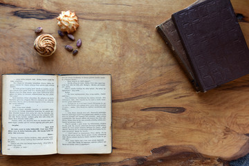 old books and cookies on wood background