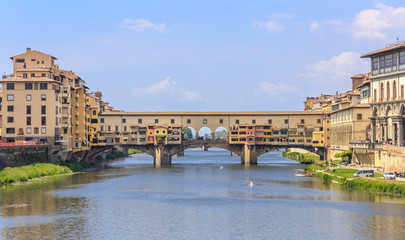Obraz premium Florence - view of river Arno and Ponte Vecchio, Florence - view of the River Arno and Ponte Vecchio. Vasari's corridor connecting Palazzo Vecchio and Palazzo Pitti runs through upper part of bridge