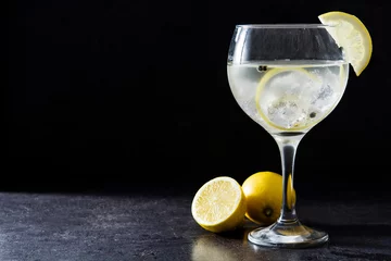Poster Alcool Verre de gin tonic au citron sur fond noir en pierre