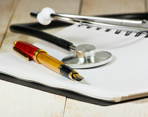 image of stethoscope, notebooks and pen on a white background