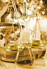 laboratory flask and scales on technological background