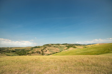 Italys Tuskany with its dry fields under blue sky