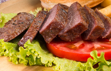 Grilled beef steaks, French fries and vegetables close-up
