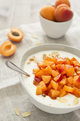 Joghurt mit Aprikosen und Mandelsplitter, mit Löffel auf Leinenserviette 
