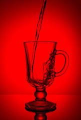 Sparkling water. Dynamic spike, thirst quenching on a hot day. Pure water on a red background.