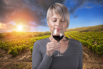 Portrait of young brunette beauty in the vineyards having wine.