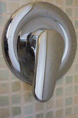 Dettaglio manico  apri acqua in metallo di una doccia di design