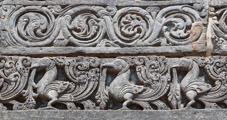Indian artwork on the Hindu temple walls with friezes, mythical swans and designed patterns. 12th centur Hoysaleshwara temple in Halebidu, India.