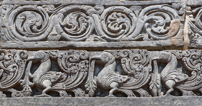Indian artwork on the Hindu temple walls with friezes, mythical swans and designed patterns. 12th centur Hoysaleshwara temple in Halebidu, India.