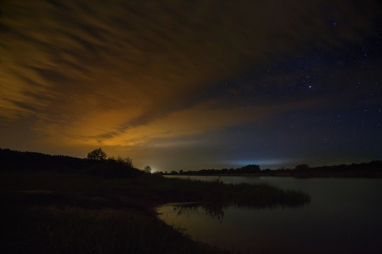Cloudy night sky over the river before dawn.