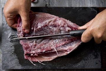 young man cutting a fresh mackerel
