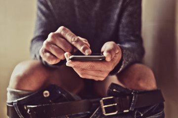 young man using his smartphone in the toilet