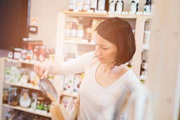 Woman puts lentil seeds into a paper bag