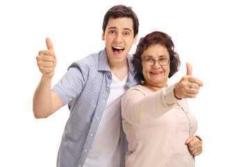 Mature woman with her grandson holding their thumbs up