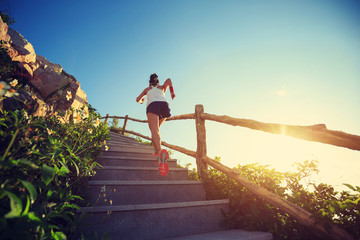 young fitness woman runner running upstairs on mountain stairs
