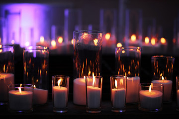 wax candles burning in stylish, glass candleholders