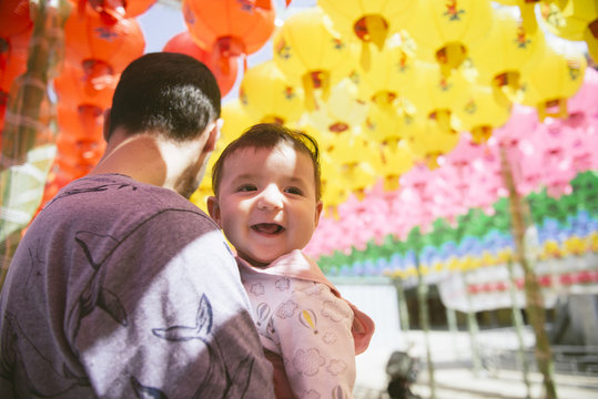 South Korea, Gyeongju, father with a baby girl under colorful paper lanterns at Bulguksa Temple
