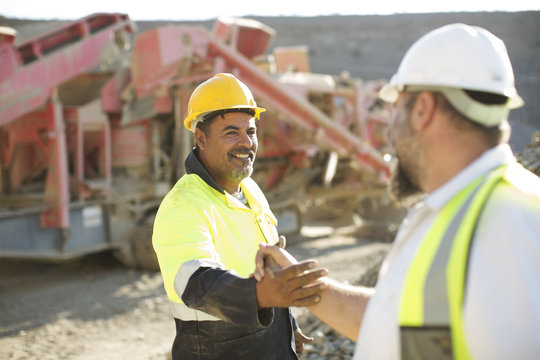 Two quarry workers shaking hands