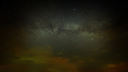 The stars of the Milky Way with clouds in the night sky.