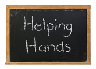 Helping Hands written in white chalk on a black chalkboard isolated on white