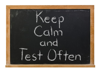 Keep Calm and Test Often written in white chalk on a black chalkboard isolated on white