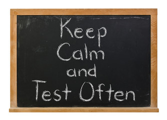 Fototapeta premium Keep Calm and Test Often written in white chalk on a black chalkboard isolated on white