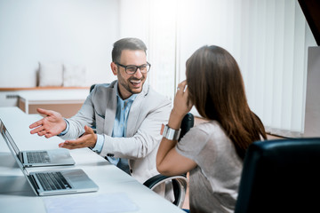 Photo of two colleagues discussing about the project in the office.