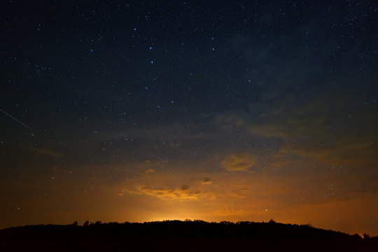 Clouds at night against the background of bright stars in the sky after sunset.