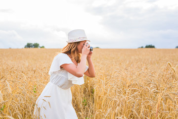 Pretty girl with vintage camera outdoors