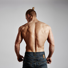 Back view of fitness man with athletic muscular torso. Concept of sport, exercise and lifestyle.