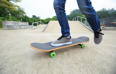 Fototapeta na wymiar skateboarder legs riding skateboard at skatepark